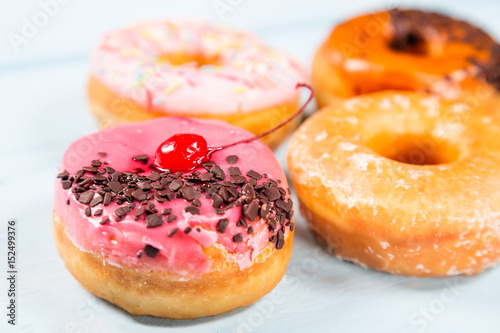 Different donuts on light blue background. Close up image with selective focus © Nikolay N. Antonov
