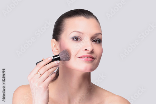 Smiling woman apply makeup