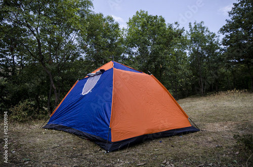 Camping and tent near the forest in could sky, Mountains of Caucasus Azerbaijan. Orange blue tent