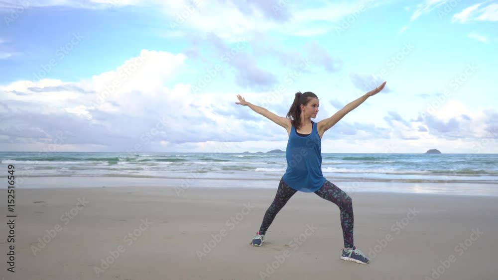 Young woman practices yoga on a beach at sunrise in front of sea. Morning gymnastic. Rise hands. Young woman practices yoga on a beach at sunrise in front of sea. Morning gymnastic. Rise hands.