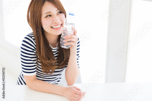 部屋で水を飲む女性