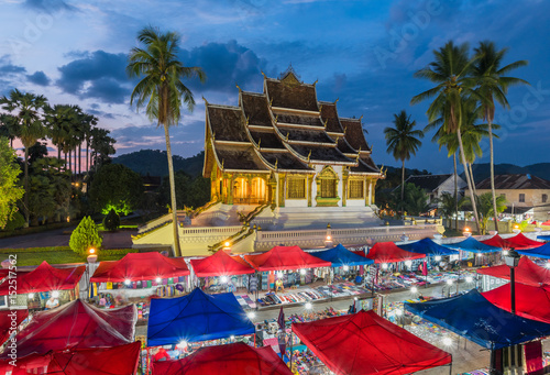 Fototapeta Naklejka Na Ścianę i Meble -  Temple in Luang Prabang Royal Palace Museum and Famous night market at twilight time,Luang Prabang, Laos. Colorful night market.UNESCO World Heritage Site in 1995.