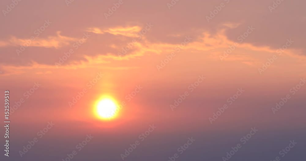 Time lapse of rising sun through dark clouds against morning glow : 4K footage