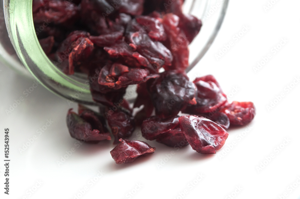 cranberries tombant d'un bocal sur fond blanc cranberries tombant d'un bocal sur fond blanc