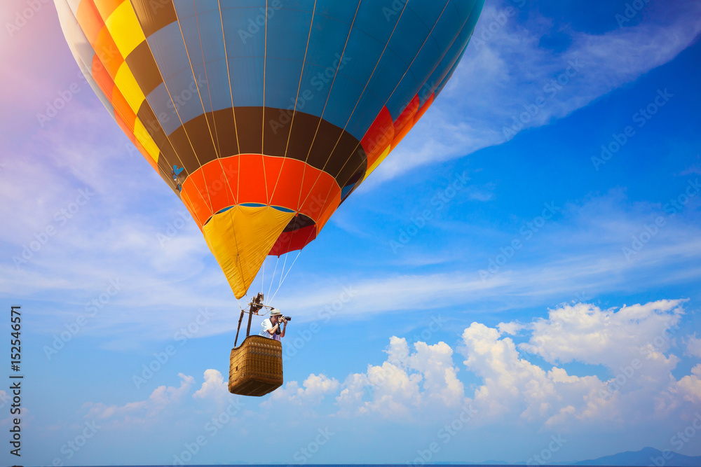 Obraz premium Hot air balloon flying over the sea with photographer
