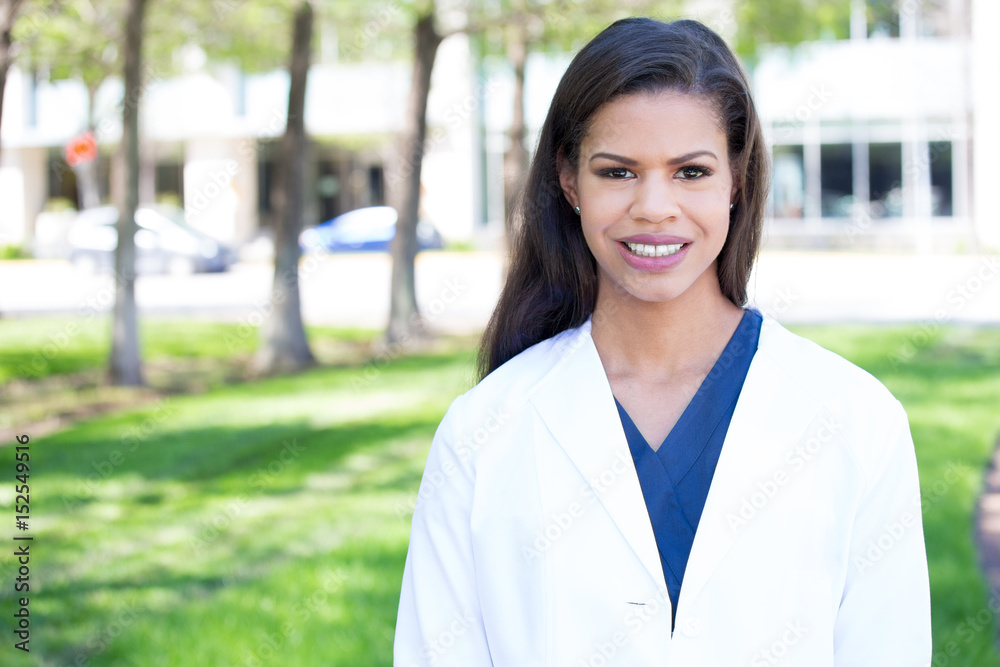 Closeup headshot portrait of friendly, smiling confident female, healthcare professional with lab coat, isolated outdoors outside background. Closeup headshot portrait of friendly, smiling confident female, healthcare professional with lab coat, isolated outdoors outside background.