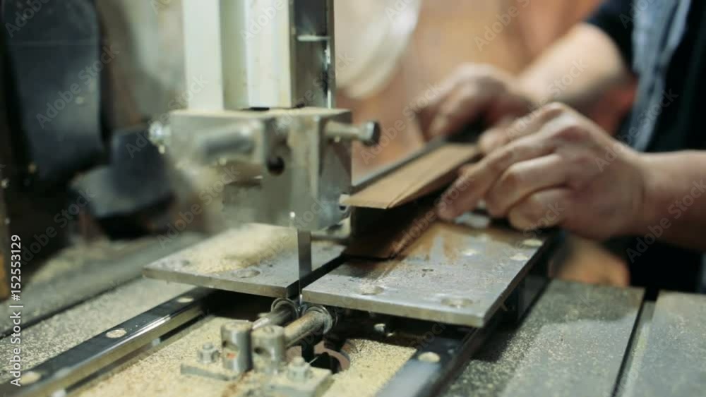 Luthier forms a billiard cue running on a band saw. Luthier forms a billiard cue running on a band saw.