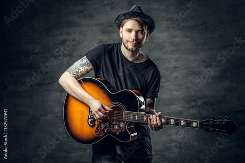 Photography Fashionable hipster blues and jazz acoustic guitar player with tattoos on his arms