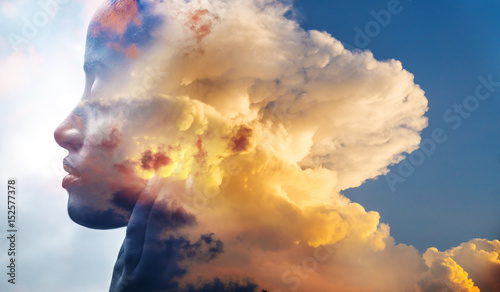 Double exposure, close-up of an African American girl and layers of stunning fluffy clouds