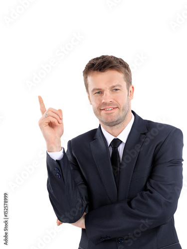 Smiling business man pointing on product or text.