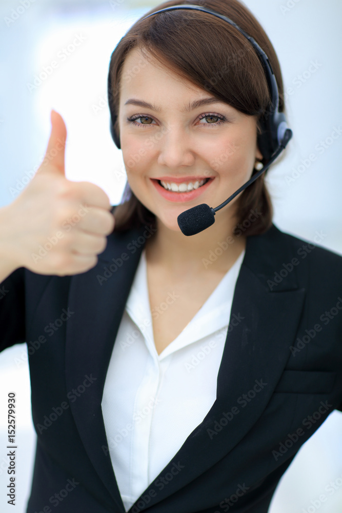 Beautiful woman working at callcenter, using headset showing thu Beautiful woman working at callcenter, using headset showing thu