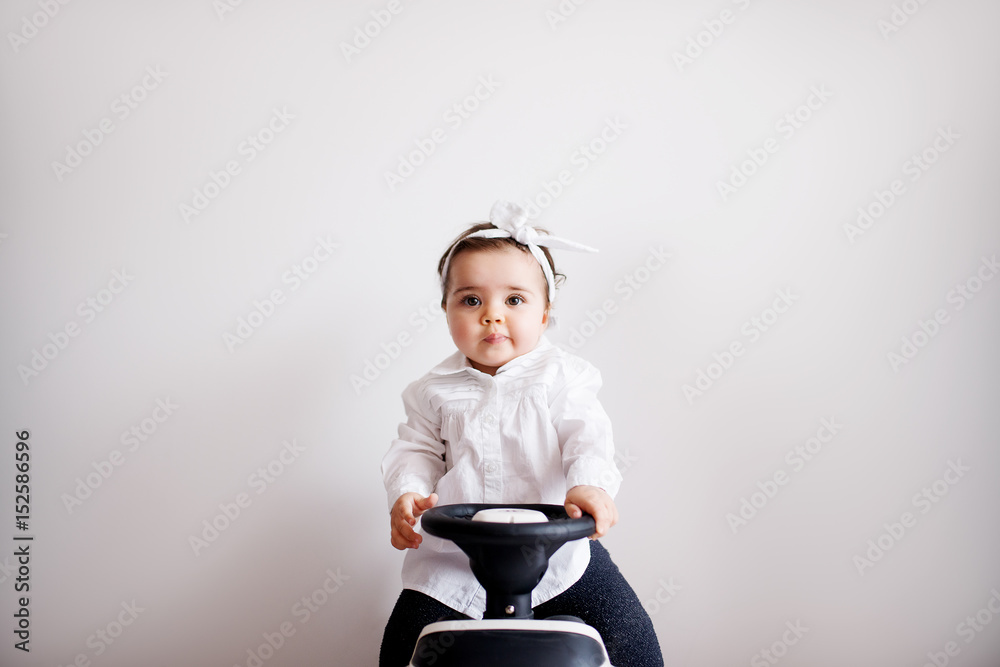 Adorable baby girl sitting on a tiny bike. Learning how to ride a bike. Adorable baby girl sitting on a tiny bike. Learning how to ride a bike.