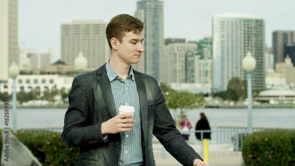 Young handsome is drinking tea on a sidewalk Young handsome is drinking tea on a sidewalk