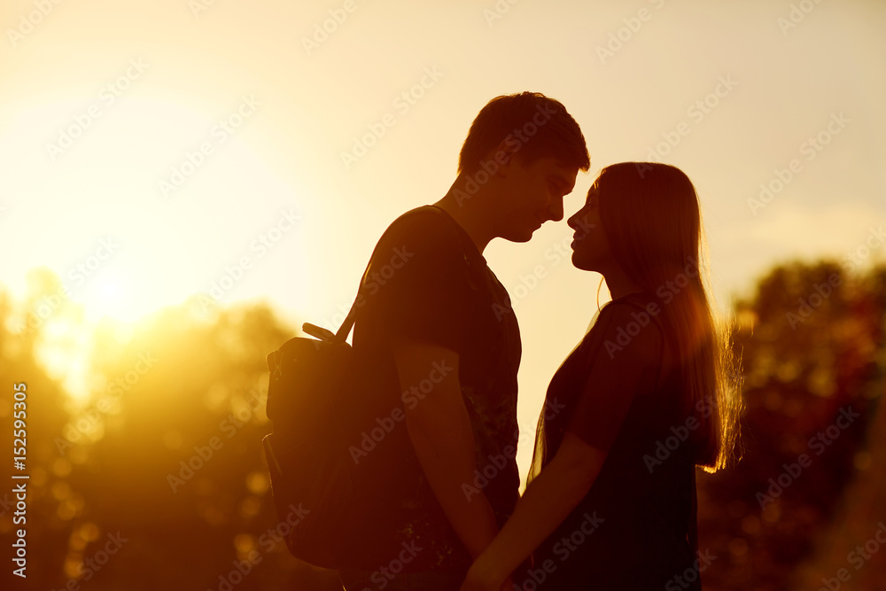 Silhouette of a loving couple at sunset in nature.