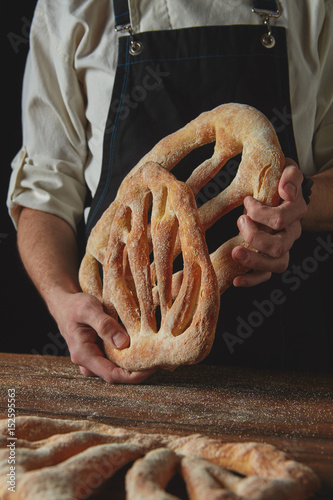 Baker is holding fougas bread photo