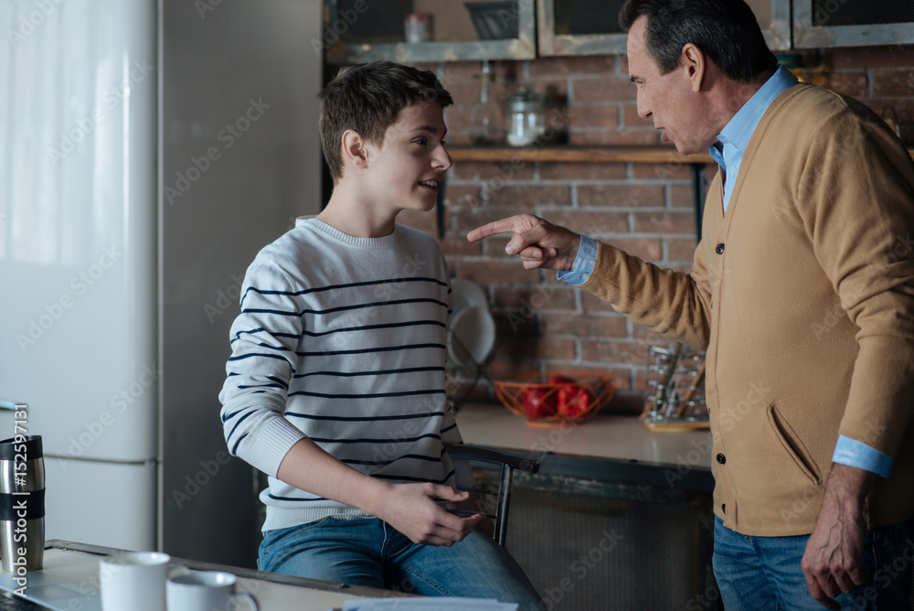 Positive delighted boy sitting on the bar chair Positive delighted boy sitting on the bar chair