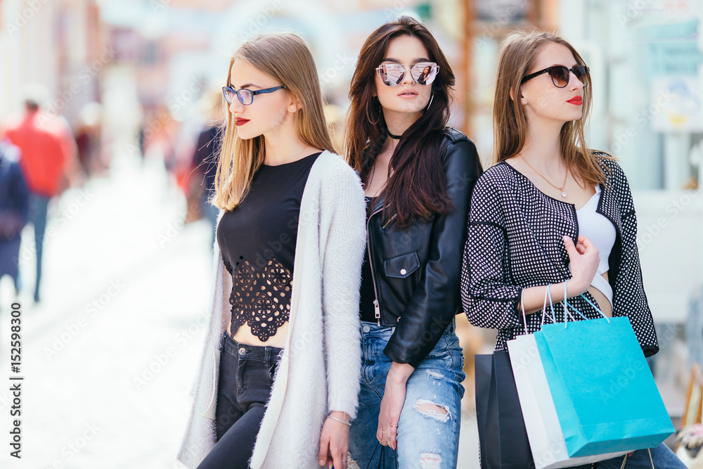 Three girls with shopping bags on park