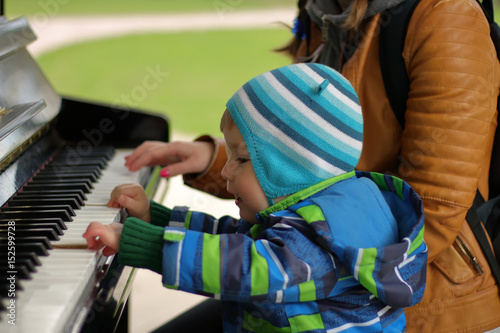 Boy of 2 years old playing piano, selective focus
