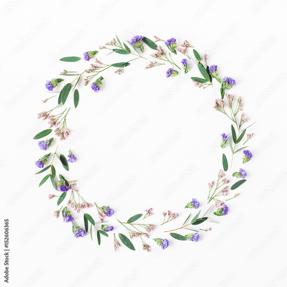 Flowers composition. Wreath made of eucalyptus leaves, purple and pink flowers on white background. Flat lay, top view Flowers composition. Wreath made of eucalyptus leaves, purple and pink flowers on white background. Flat lay, top view