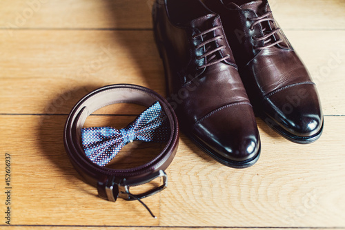 watch, Brown bow tie, leather shoes and belt. Grooms wedding morning. Close up of modern man accessories