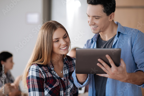Two coworkers watching advertising in tablet