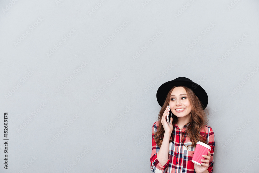 Casual smiling woman in hat talking on mobile phone Casual smiling woman in hat talking on mobile phone