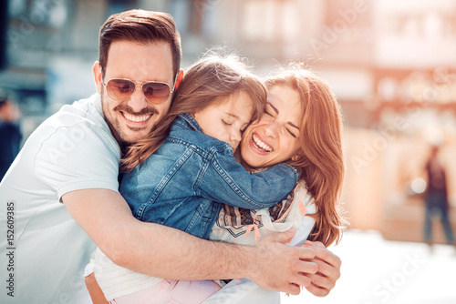 Happy young family in city street