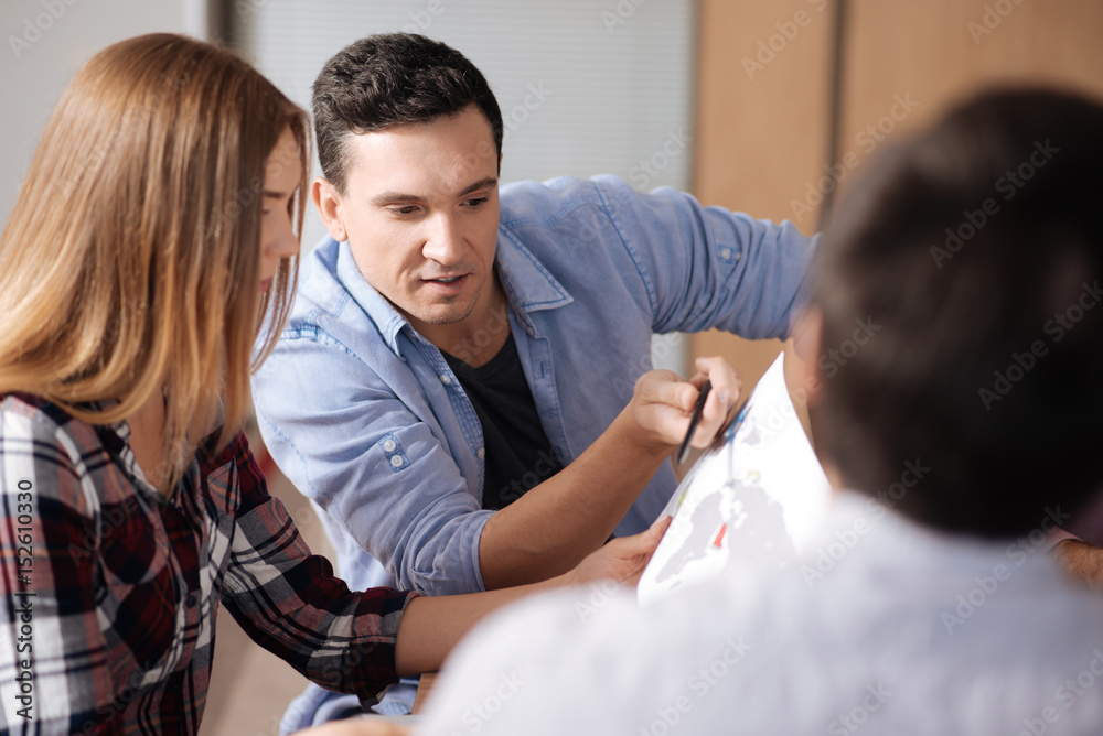 Fototapeta premium Serious male person telling something to his colleague