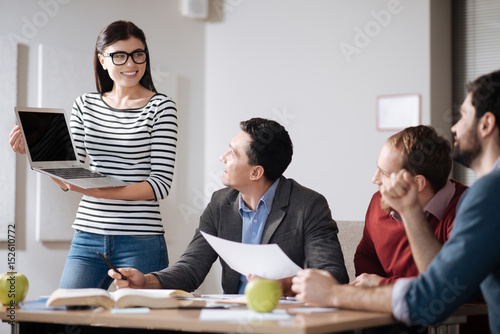 Photos Positive delighted woman showing her presentation to colleagues