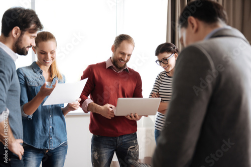 Company of five people actively discussing new project photo