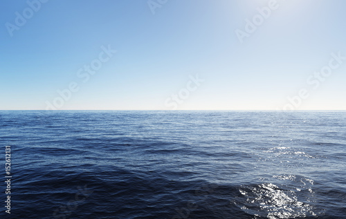 clear blue sky above rippled ocean water with sunlight reflection