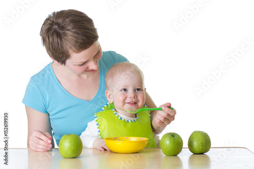 Mother spoon-feeding her ba...