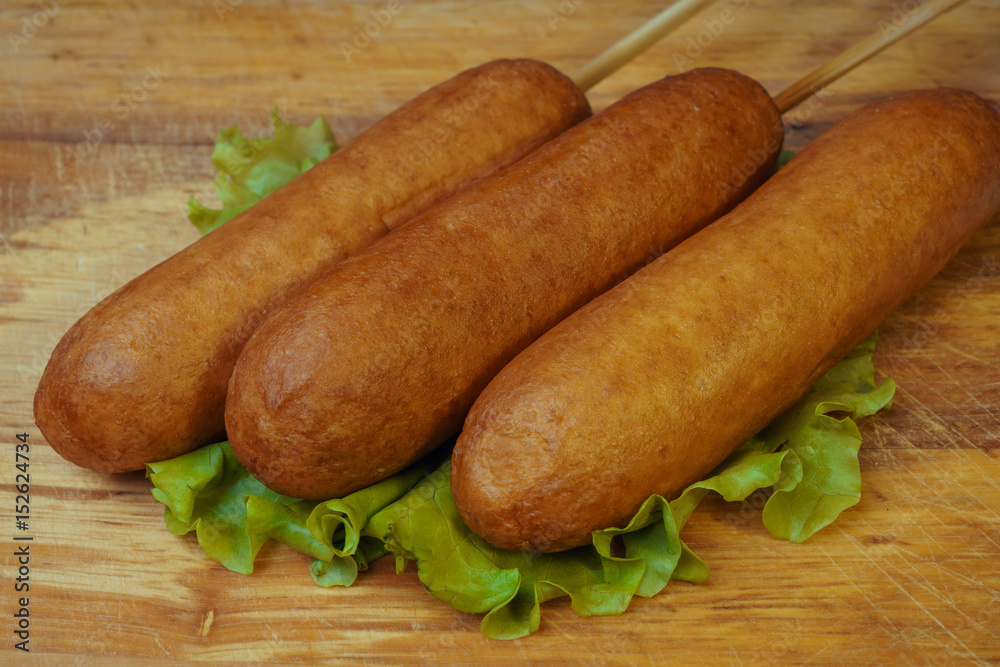 Traditional American food corn dogs on a lettuce leaf. fast food. Traditional American food corn dogs on a lettuce leaf. fast food.