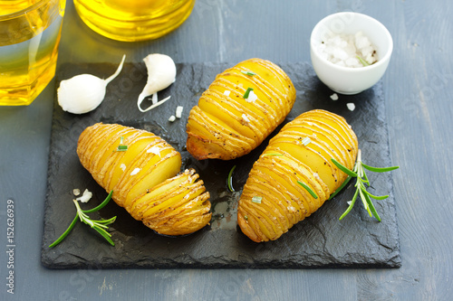 Baked potatoes "accordion" with garlic and rosemary.