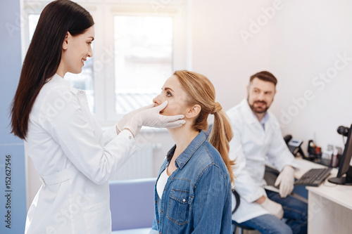 Cheerful delighted doctor looking into her patients face
