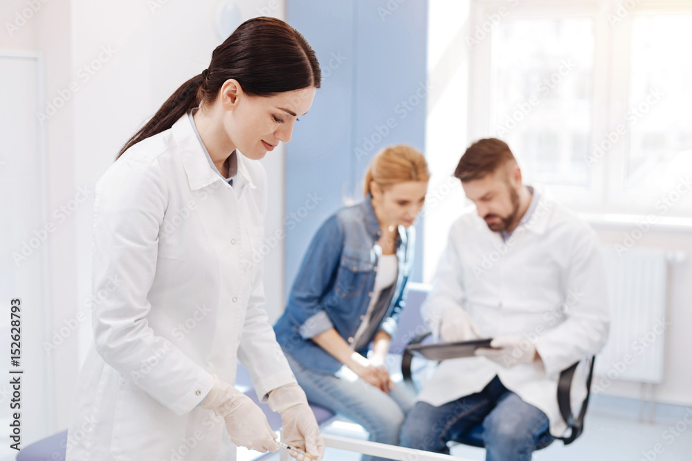 Nice professional doctor preparing a syringe Nice professional doctor preparing a syringe
