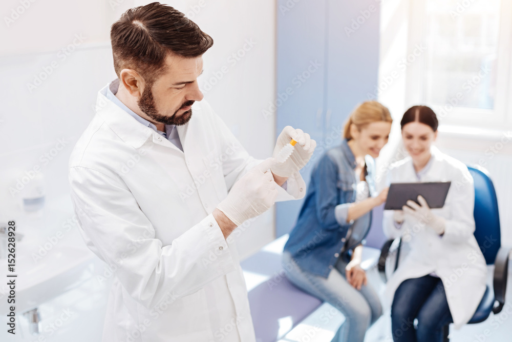 Obraz premium Handsome male doctor holding a special bottle