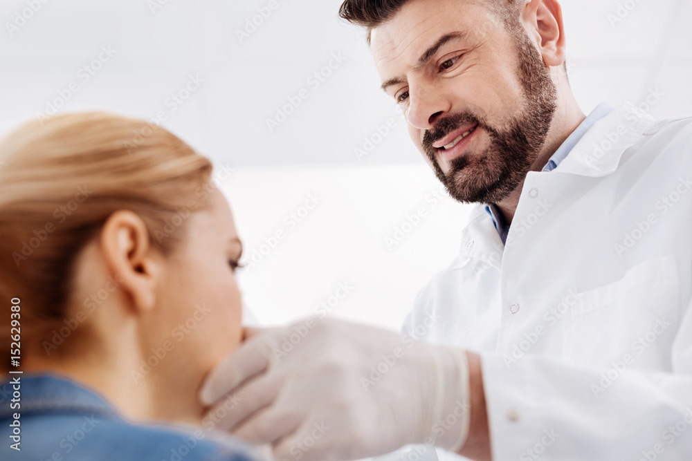 Cheerful joyful doctor looking at his patient