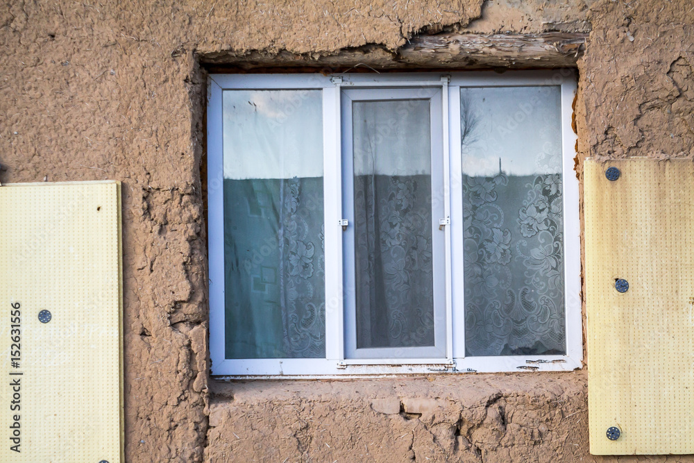 Plastic window in the old house from adobe Plastic window in the old house from adobe