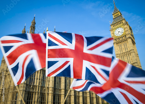 Great British Union Jack flag sflying in motion blur in front of Big Ben and the Houses of Parliament at Westminster Palace, London, UK photo