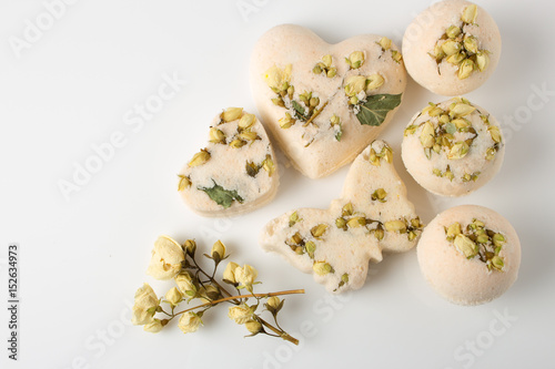 Bath bombs decorated with dried linden flowers on a white