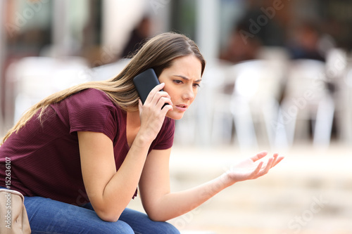 Фотография Angry woman calling on the phone in the street