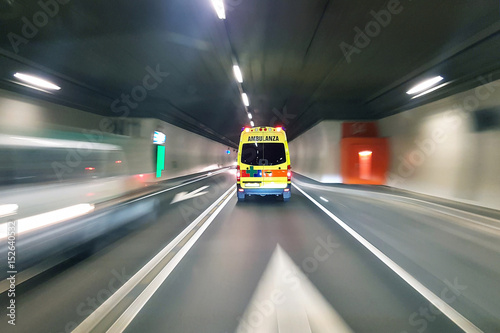 Ambulance speeding in road tunnel with traffic motion blur background