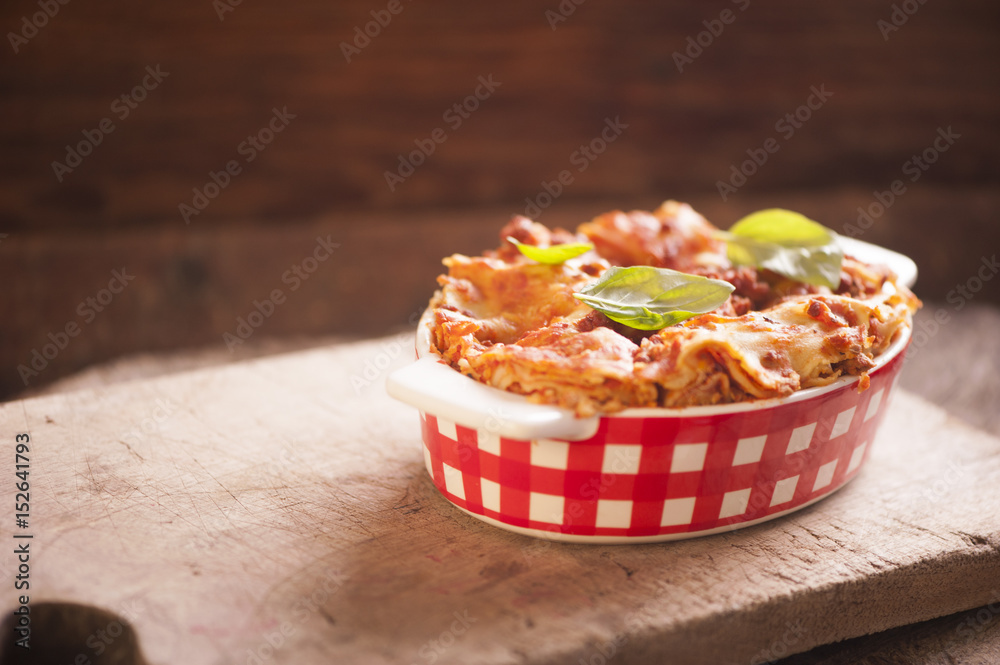 Lasagna bolognese in a baking dish on a rustic table Lasagna bolognese in a baking dish on a rustic table