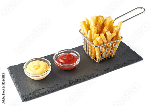 Crispy french fries in the basket with catchup and cheese sauce isolated on white background