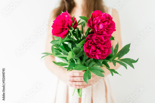 Fototapeta Naklejka Na Ścianę i Meble -  Happy young woman holding in hands peony bouquet. Sweet romantic moment