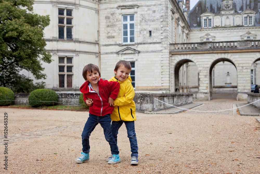 Two children, playing in the rain in front of the Le Lude castle