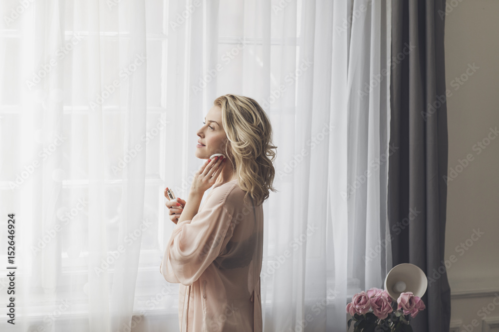 Pretty blonde Caucasian woman celaning her face with lotion and cotton pad. Pretty blonde Caucasian woman celaning her face with lotion and cotton pad.