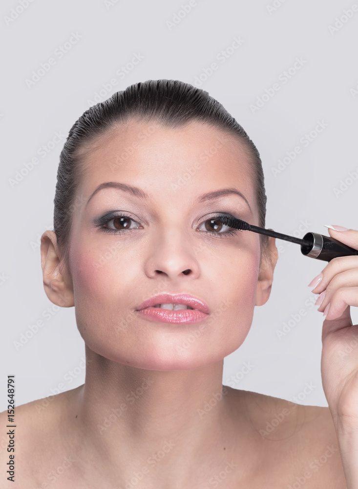 Beautiful woman is using mascara