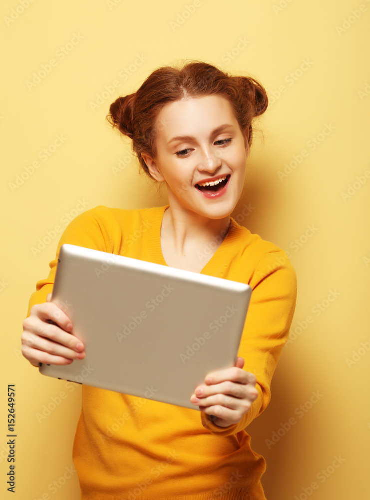 young woman with tablet pc over yellow background young woman with tablet pc over yellow background